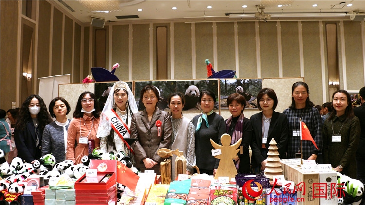 中國駐日本大使吳江浩夫人丁玥（左五）與使館人員在展位前合影留念。人民網(wǎng) 許可攝