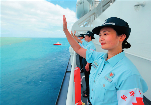 中國(guó)海軍“和平方舟”號(hào)醫(yī)院船結(jié)束訪問(wèn)湯加時(shí)，任務(wù)官兵中的文職人員向歡送人群揮手告別（2023年8月4日攝）。徐巍攝/本刊