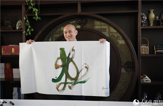 老撾駐華大使館三秘明君參加《五百筆·瀾湄合作》集體藝術(shù)創(chuàng)作。人民網(wǎng)王婧攝。