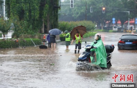 5月10日，廣西沿海遭遇強(qiáng)降雨。圖為欽州市民眾在積澇中出行。陸敏 攝