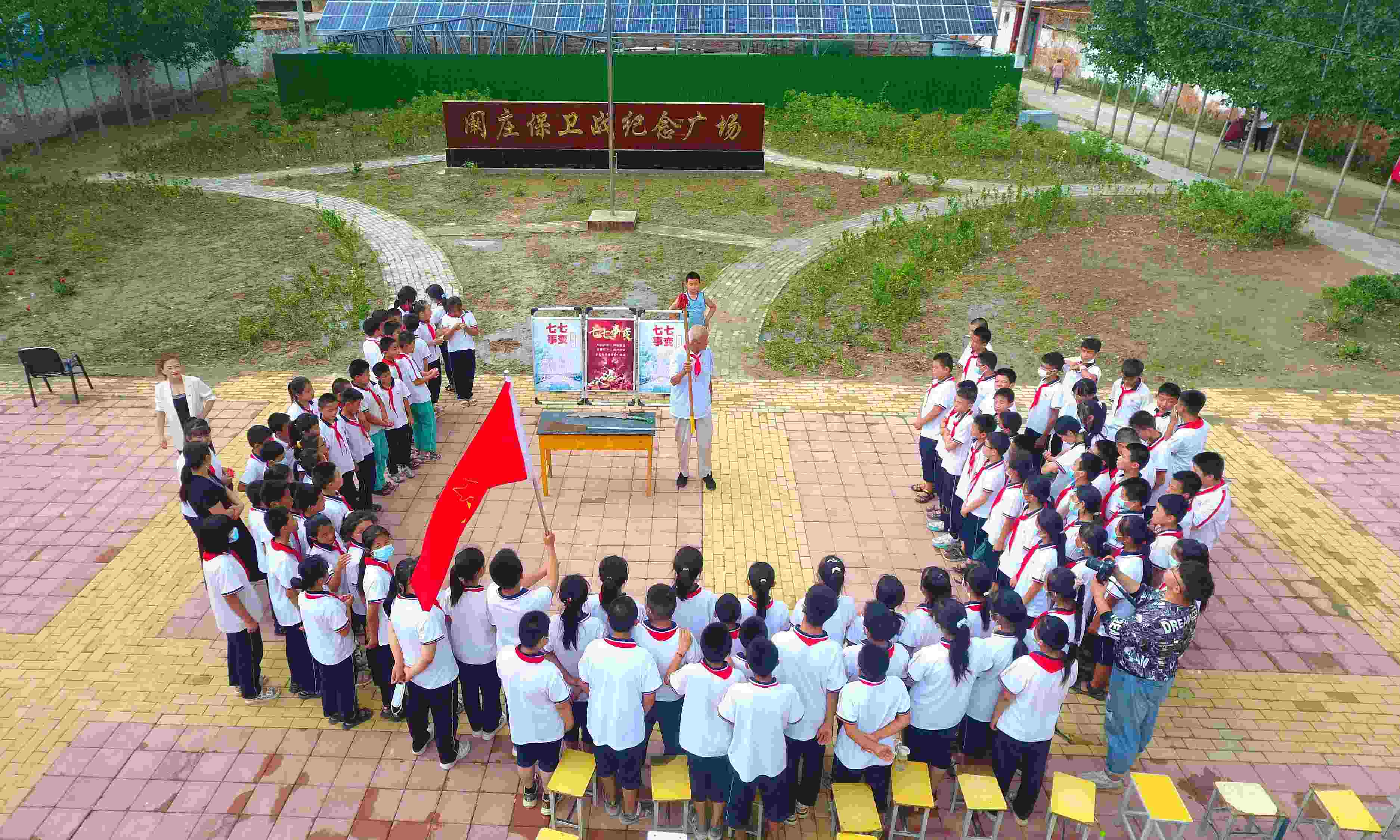 2022年7月6日，山東省聊城市，在茌平區(qū)菜屯鎮(zhèn)闞莊村的闞莊保衛(wèi)戰(zhàn)紀(jì)念廣場，闞莊保衛(wèi)戰(zhàn)親歷者王光木老人為小學(xué)生們講述抗戰(zhàn)故事，展示大刀、長矛。