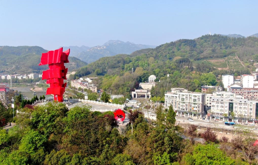 這是2021年4月9日拍攝的鄂豫皖蘇區(qū)首府革命博物館附近的英雄山上的“紅旗飄飄”主題雕塑（無人機照片）。新華社發(fā)