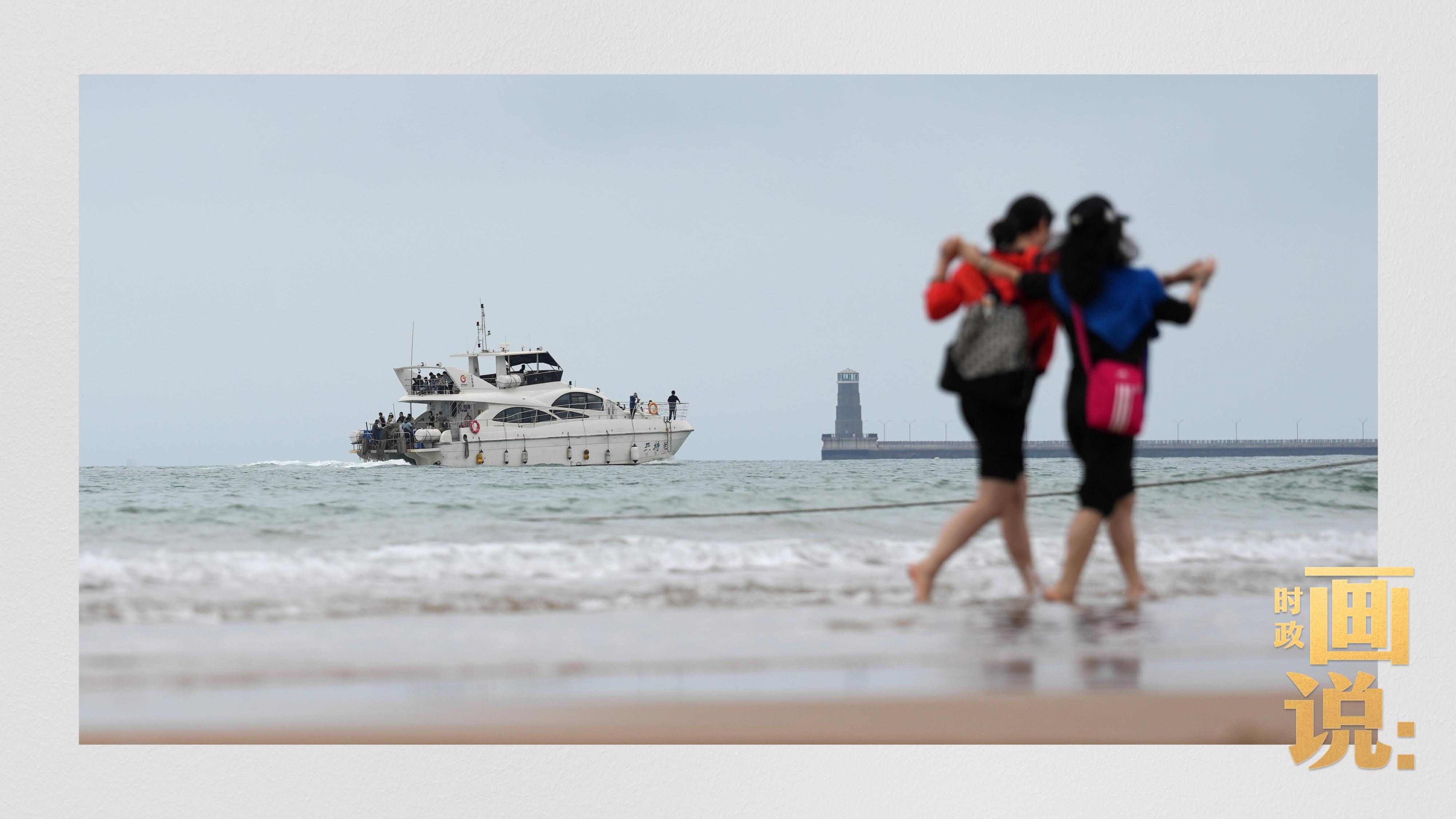△日照陽光海岸綠道上的萬平口景區(qū)，一對游客在海浪中翩然起舞。