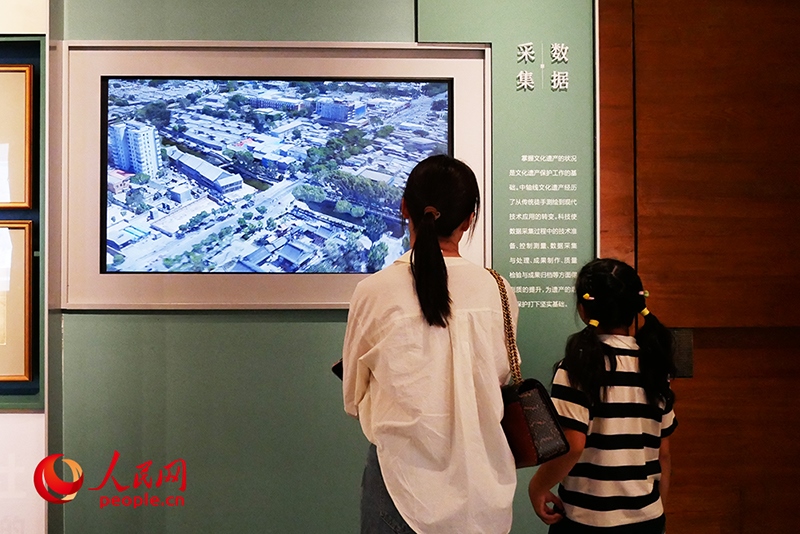 家長正在帶孩子參觀“輝煌中軸”專題展。人民網(wǎng)記者 韋衍行攝