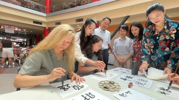 羅馬尼亞友人在活動現(xiàn)場學(xué)寫漢字。中國駐羅馬尼亞大使館領(lǐng)僑處供圖