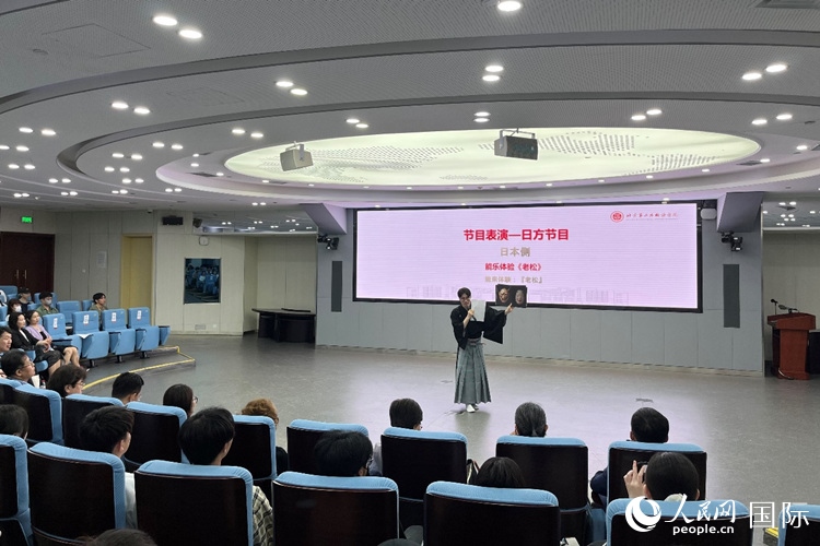 日本大學(xué)生介紹能樂知識。人民網(wǎng)記者 陳思攝