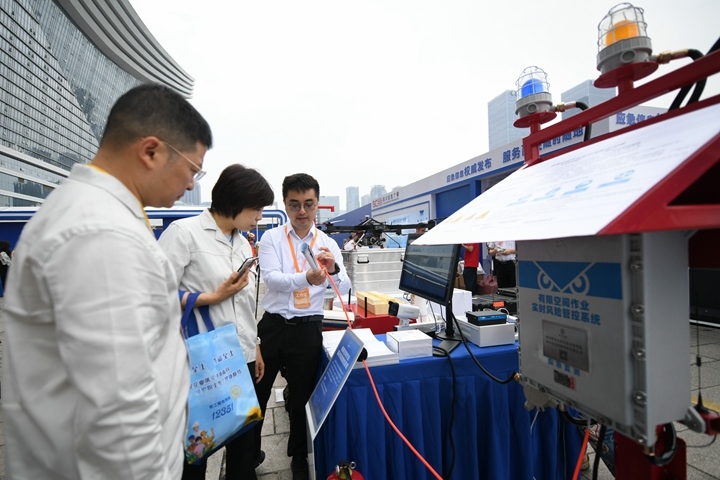 6月16日，在全國“安全宣傳咨詢?nèi)铡敝鲌龌顒由?，四川省安全科學(xué)技術(shù)研究院工作人員（右一）向參觀者介紹“有限空間作業(yè)實時風(fēng)險管控系統(tǒng)”。新華社記者胥冰潔攝