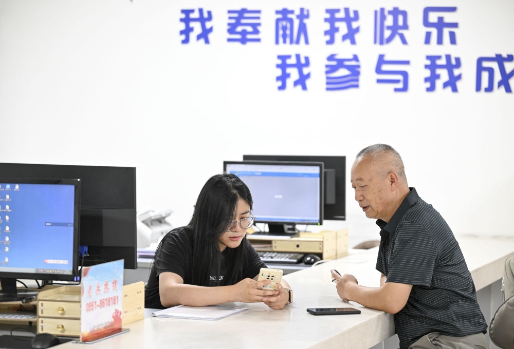 6月20日，在長(zhǎng)城花園社區(qū)黨群服務(wù)中心，工作人員幫助居民辦理業(yè)務(wù)。
