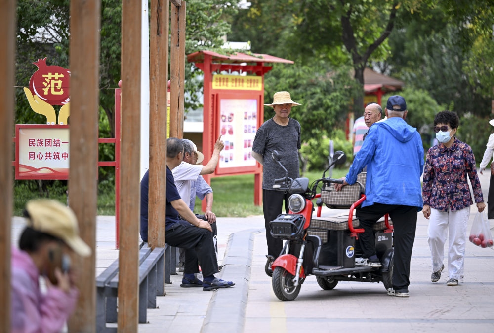 6月20日，長(zhǎng)城花園社區(qū)的居民在休閑、聊天。
