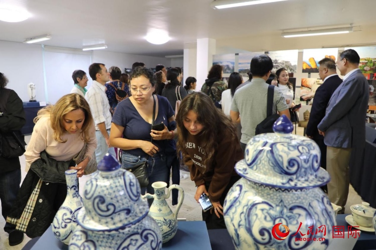 在展覽現(xiàn)場，觀眾們駐足欣賞德化瓷和墨西哥彩瓷。人民網 埃內斯托·多明戈斯攝