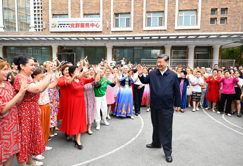 2022年7月13日，習近平總書記在新疆烏魯木齊市天山區(qū)固原巷社區(qū)考察時，向各族群眾揮手致意。