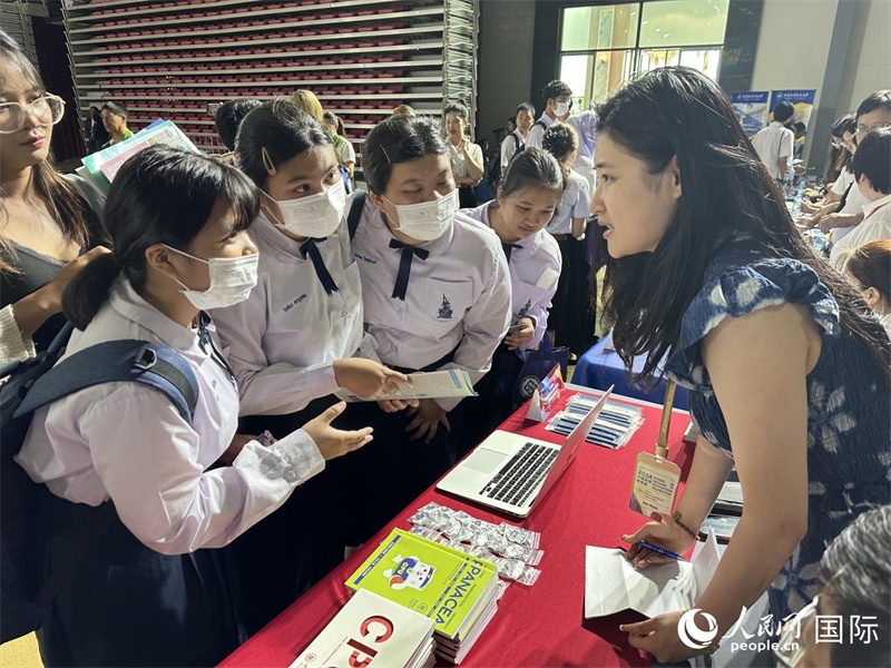 來自泰國的學生、家長在教育展臺前咨詢。人民網(wǎng)記者 簡承淵攝