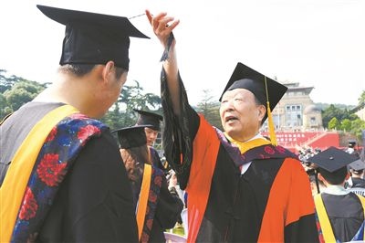 2017年6月22日，李德仁（右一）參加武漢大學(xué)畢業(yè)典禮并為畢業(yè)生撥穗。
