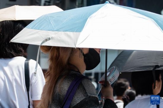 7月4日，人們?cè)谌毡緰|京原宿的街道上等待紅綠燈。新華社記者 張笑宇 攝