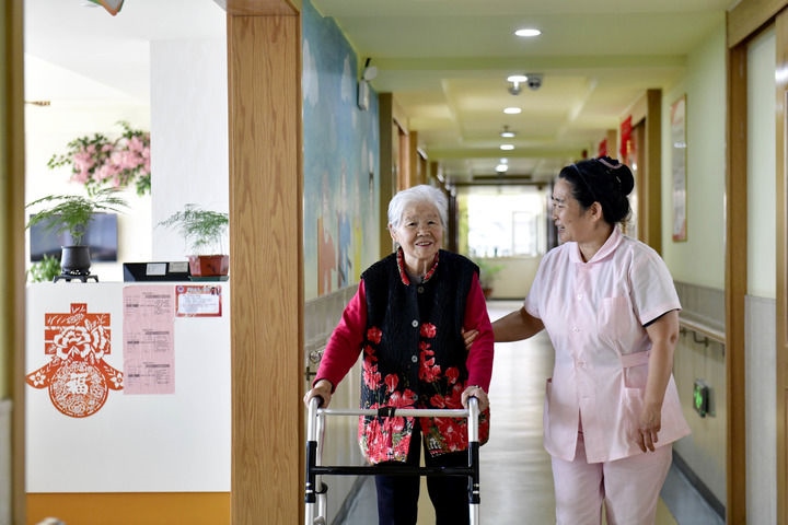 2024年5月25日，在山東省日照市東港區(qū)石臼街道日照幸福護(hù)理院，工作人員在陪護(hù)老人。新華社記者 郭緒雷 攝