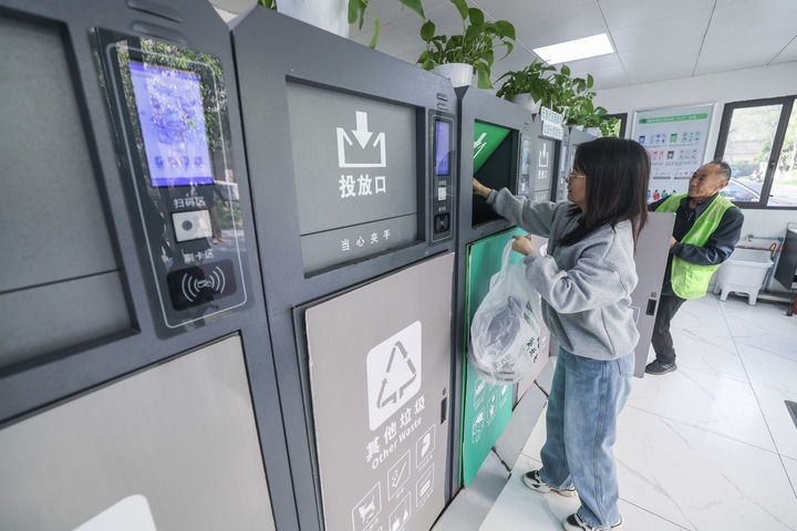 2024年4月10日，在浙江省湖州市吳興區(qū)飛英街道新華府小區(qū)內(nèi)，居民在垃圾分類智能系統(tǒng)的指導(dǎo)下進(jìn)行垃圾分類投放，居民的投放情況將實(shí)時(shí)匯總到智慧服務(wù)平臺(tái)，會(huì)有相應(yīng)的積分獎(jiǎng)勵(lì)。新華社記者 徐昱 攝