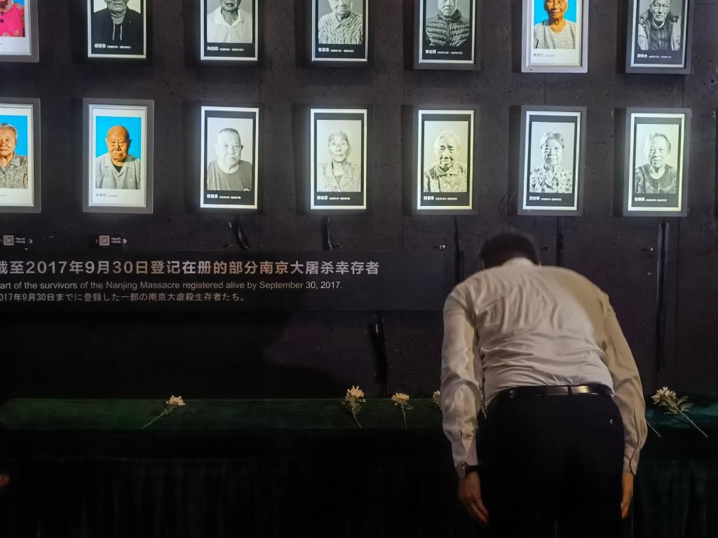 7月18日，人們向離世的南京大屠殺幸存者獻花、鞠躬。新華社記者邱冰清 攝