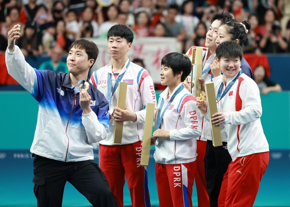 冠軍中國組合王楚欽（右三）/孫穎莎（右一）、亞軍朝鮮組合李正植（左二）/金琴英（左三）、季軍韓國組合林鐘勛（左一）/申裕斌在巴黎奧運會乒乓球混雙頒獎儀式上合影（2024年7月30日攝）。新華社記者 劉續(xù) 攝