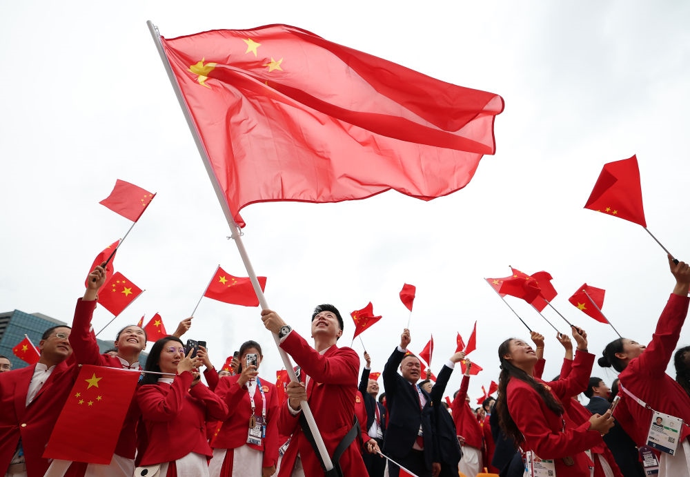 中國體育代表團(tuán)旗手、乒乓球選手馬龍在第33屆夏季奧林匹克運動會開幕式前揮舞國旗（2024年7月26日攝）。新華社記者 曹燦 攝