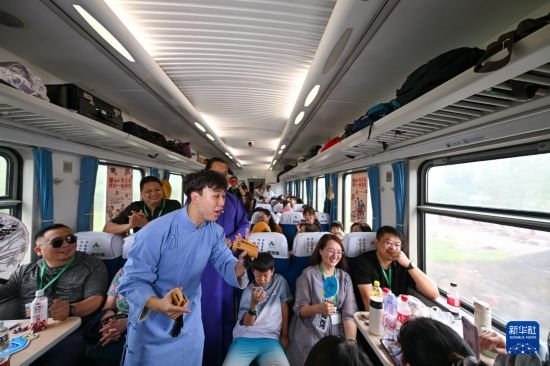 9月7日，相聲演員在S910列車上為旅客表演快板。