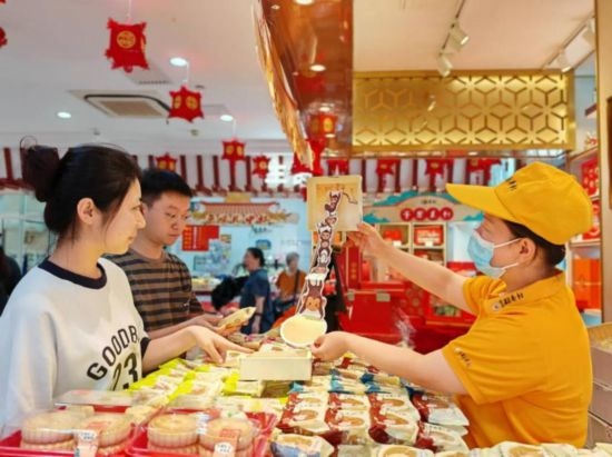 北京稻香村一家門店內(nèi)，售貨員向顧客展示新上市的月餅禮盒。（受訪者供圖）
