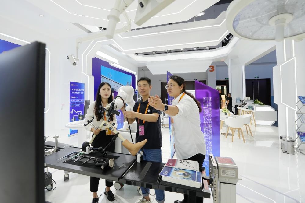 9月11日，一位媒體記者（中）在2024年服貿(mào)會(huì)國家會(huì)議中心會(huì)場體驗(yàn)北京納通科技集團(tuán)有限公司的膝關(guān)節(jié)置換手術(shù)機(jī)器人。新華社記者鞠煥宗 攝