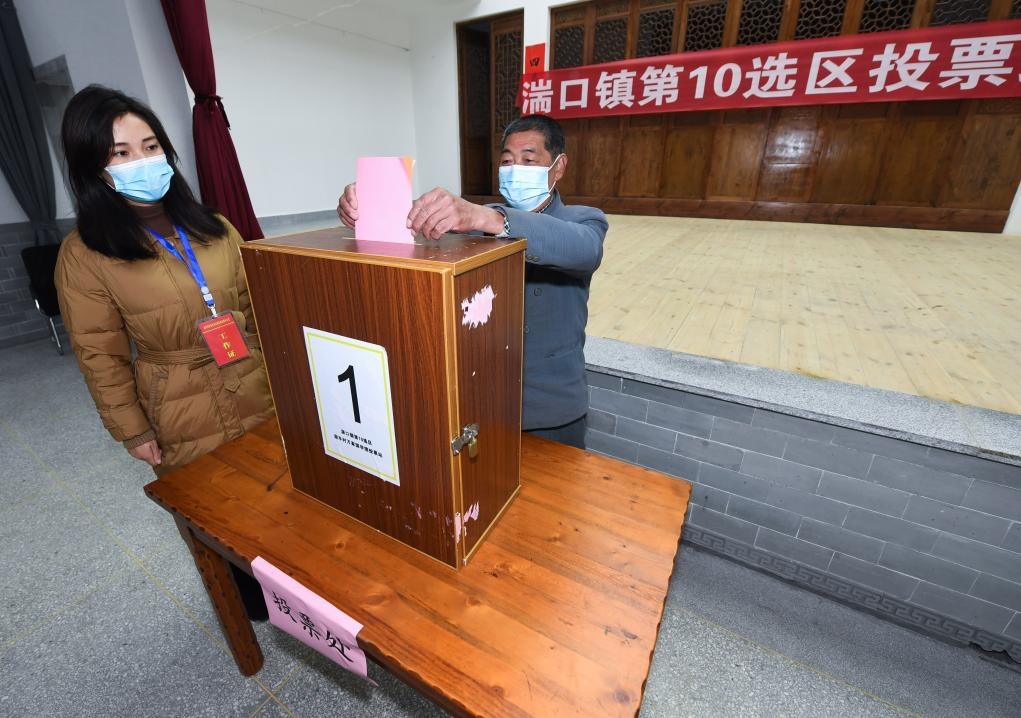 2021年12月14日，在浙江省杭州市臨安區(qū)湍口鎮(zhèn)迎豐村的基層投票點(diǎn)，村民在參加投票，村級監(jiān)察聯(lián)絡(luò)員監(jiān)票。新華社記者 徐昱 攝