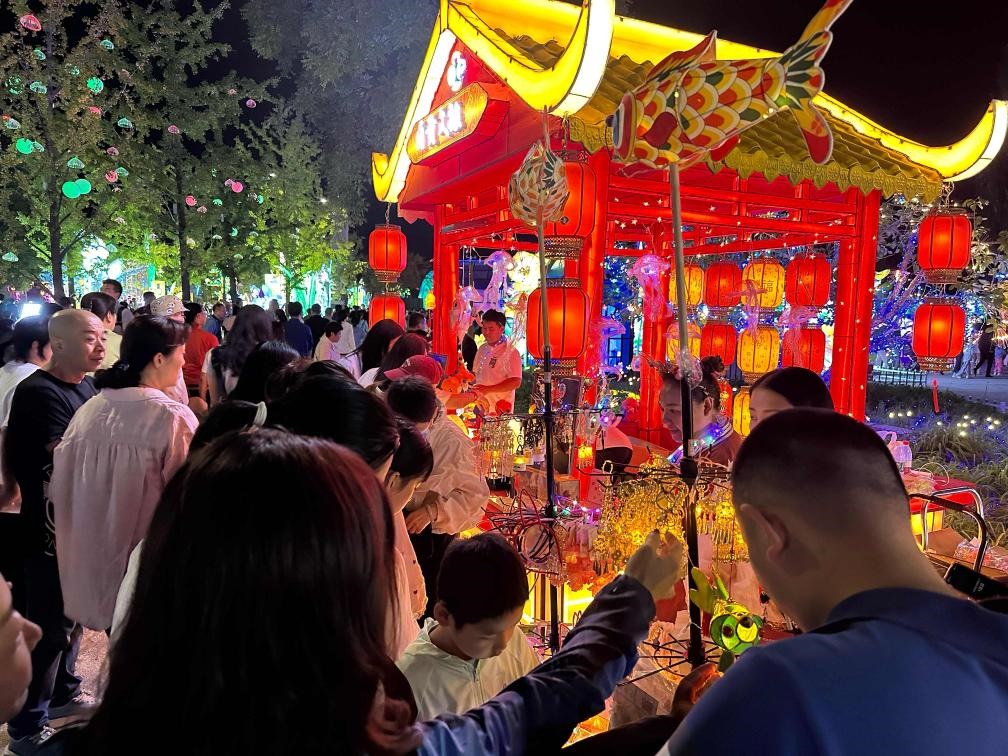 市民游客在2024年北京中秋國(guó)慶彩燈游園會(huì)上選購(gòu)特色文創(chuàng)商品。新華社記者楊淑君 攝