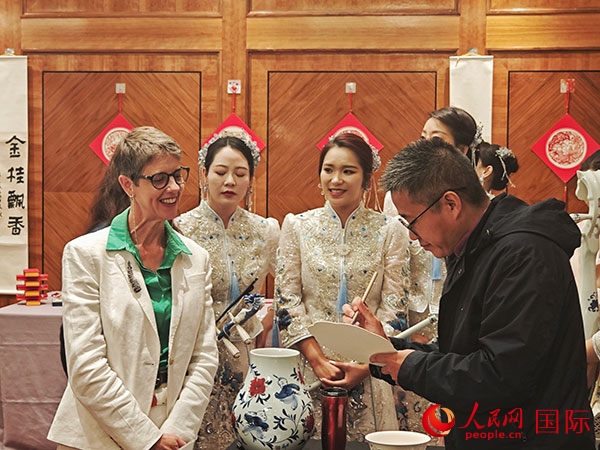 現(xiàn)場的非遺傳承人為英國觀眾展示畫技。人民網(wǎng)記者 邢雪攝