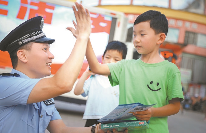 ▲7月10日，江西省吉安市公安局吉州分局組織民警深入轄區(qū)開展安全宣傳，民警向小朋友講解防溺水知識(shí)。朱文杰攝