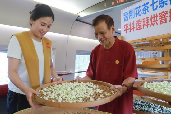 10月1日，福州市茉莉花茶窨制工藝代表性傳承人張子建與旅客在G1634次列車上制作茉莉花茶。新華社記者周義 攝