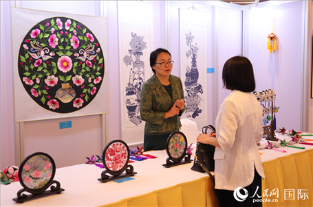青海非遺文化傳承人向嘉賓介紹展品。人民網(wǎng)實(shí)習(xí)生姚欣可攝