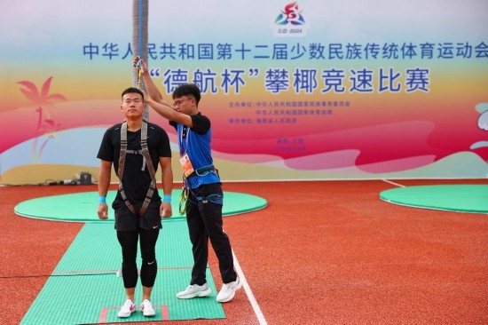 11月23日，工作人員為上海隊(duì)選手付樂樂（左）系安全繩。新華社記者 楊植森 攝