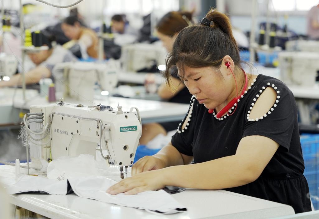 5月20日，村民在李寨村服裝加工廠內(nèi)忙碌。河南省周口市沈丘縣馮營鎮(zhèn)李寨村地處豫東平原。近年來，乘著脫貧攻堅(jiān)與鄉(xiāng)村振興政策的東風(fēng)，李寨村積極探索產(chǎn)業(yè)發(fā)展模式，通過“龍頭企業(yè)+村集體經(jīng)濟(jì)+農(nóng)戶”的方式，逐漸發(fā)展形成肉牛養(yǎng)殖、設(shè)施農(nóng)業(yè)、服裝加工、康養(yǎng)民宿等產(chǎn)業(yè)，以產(chǎn)業(yè)振興助力鄉(xiāng)村振興。新華社記者 李嘉南 攝