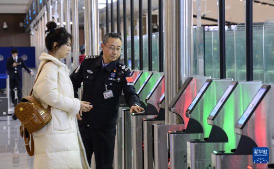 1月2日，大興機場邊檢站警察指導旅客使用自助出境設備。新華社記者 李欣 攝