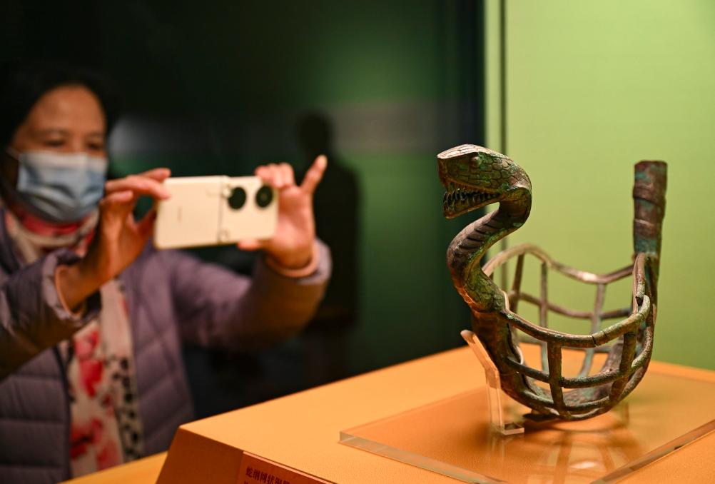1月14日，觀眾在上海博物館蛇年迎春展拍攝展品蛇綱網(wǎng)狀銅器。新華社發(fā)（陳浩明攝）