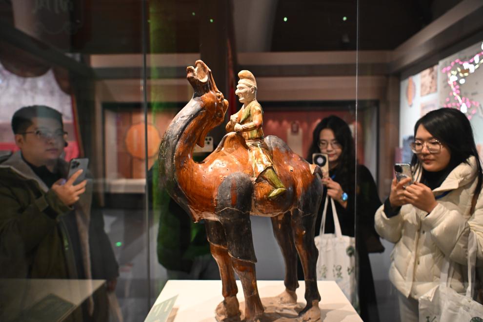 1月15日，觀眾在拍攝“長(zhǎng)安三萬(wàn)里——陜西唐代文物精華展”展出的三彩胡人騎駝俑。（新華社記者 孫凡越 攝）
