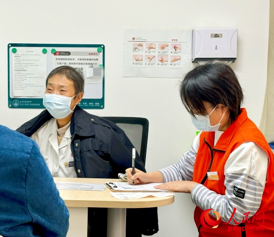 秦苑（中）接診患者。人民網(wǎng)記者 金慧慧攝