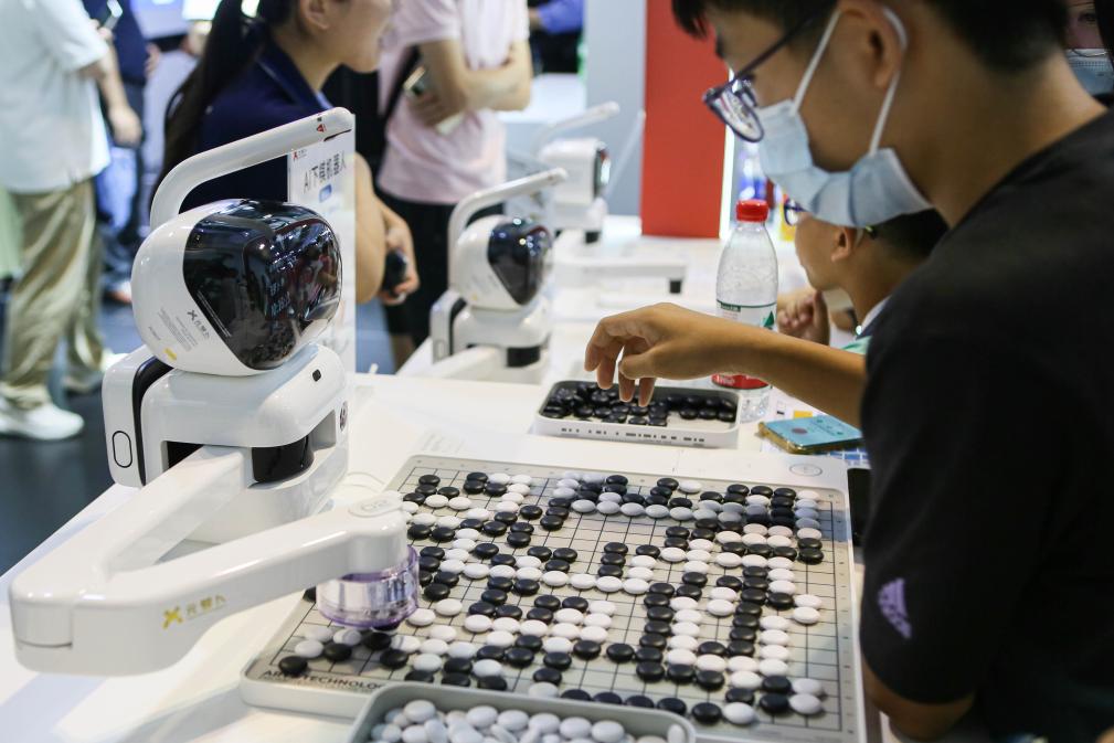 2023年7月7日，元蘿卜AI下棋機(jī)器人與觀眾對弈。2023年7月6日至8日，2023世界人工智能大會在上海舉行。新華社記者 辛夢晨 攝