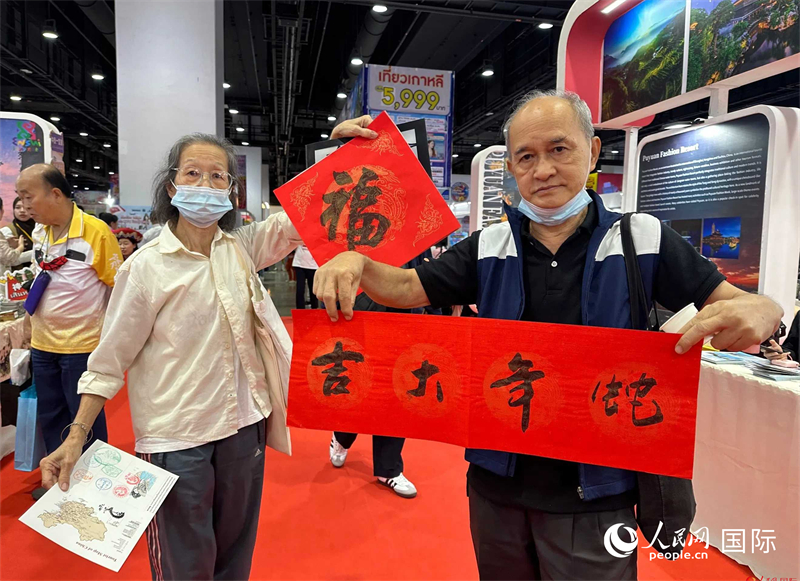 2025蛇年春節(jié)，泰國市民展示他們領(lǐng)到的華人手寫春聯(lián)。人民網(wǎng)記者 簡承淵攝